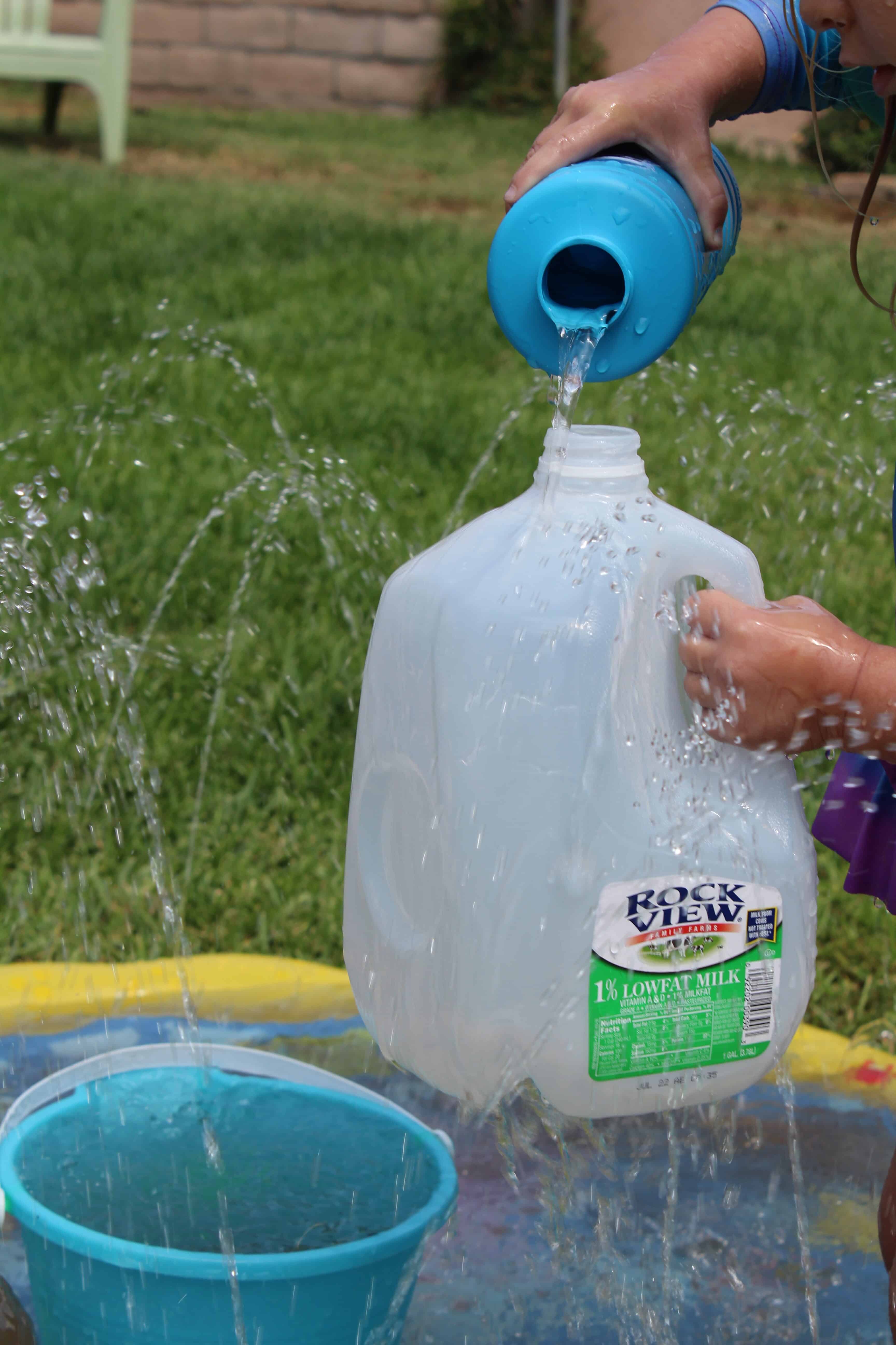 kids using milk jugs to play with water