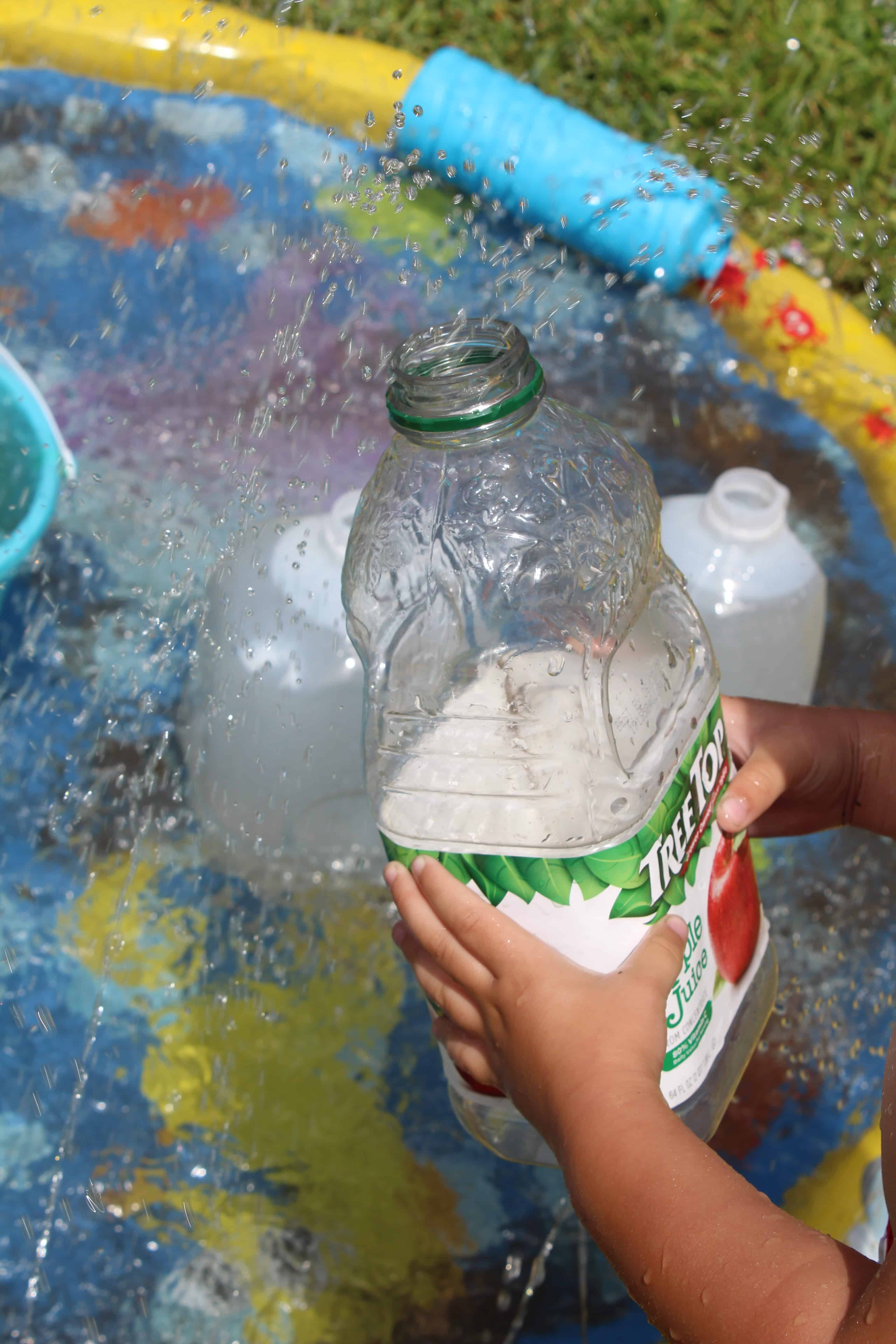 Empty apple juice bottle being used to collect water.