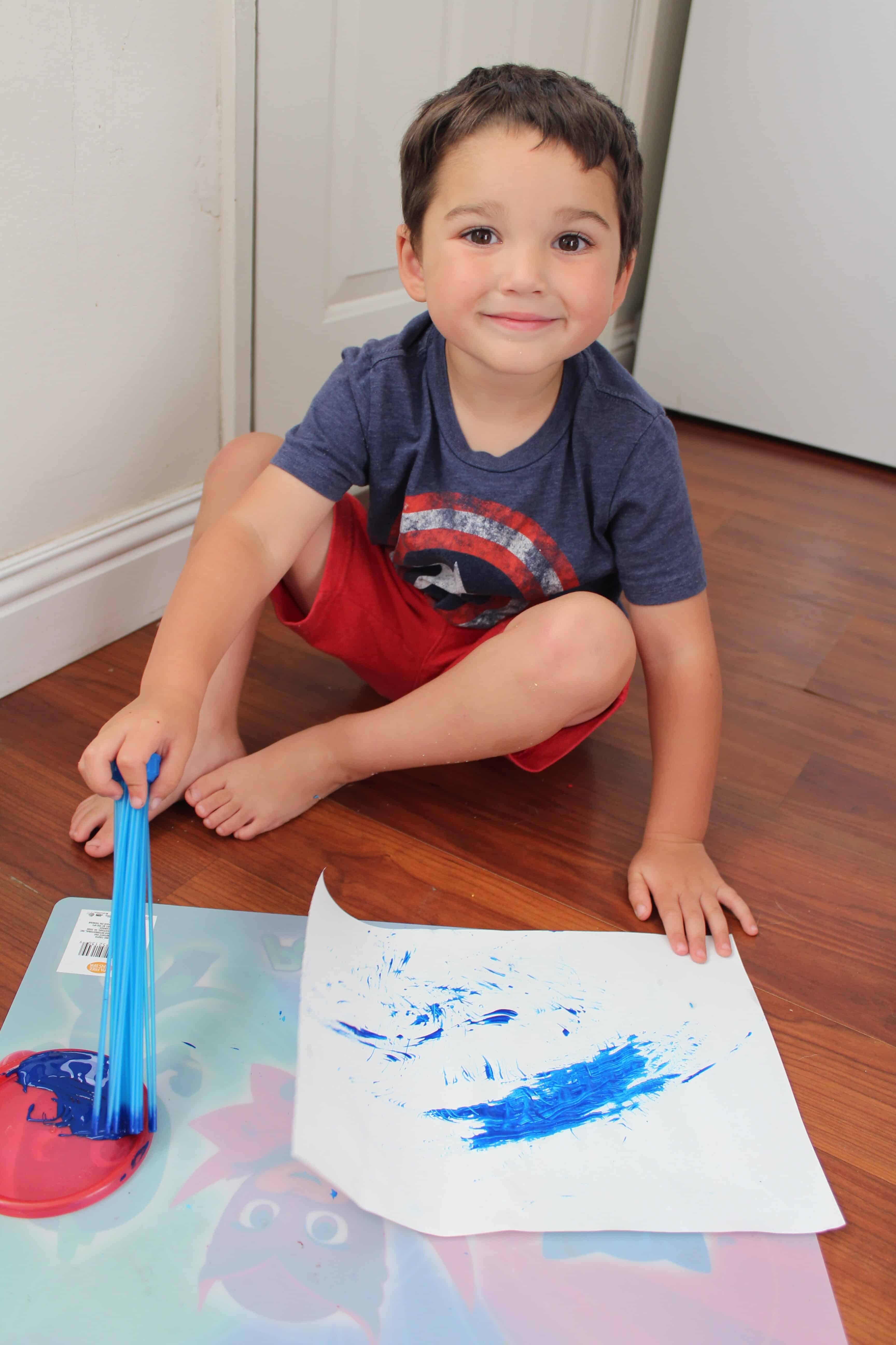 preschooler using recycled materials (bunch a balloons) to paint