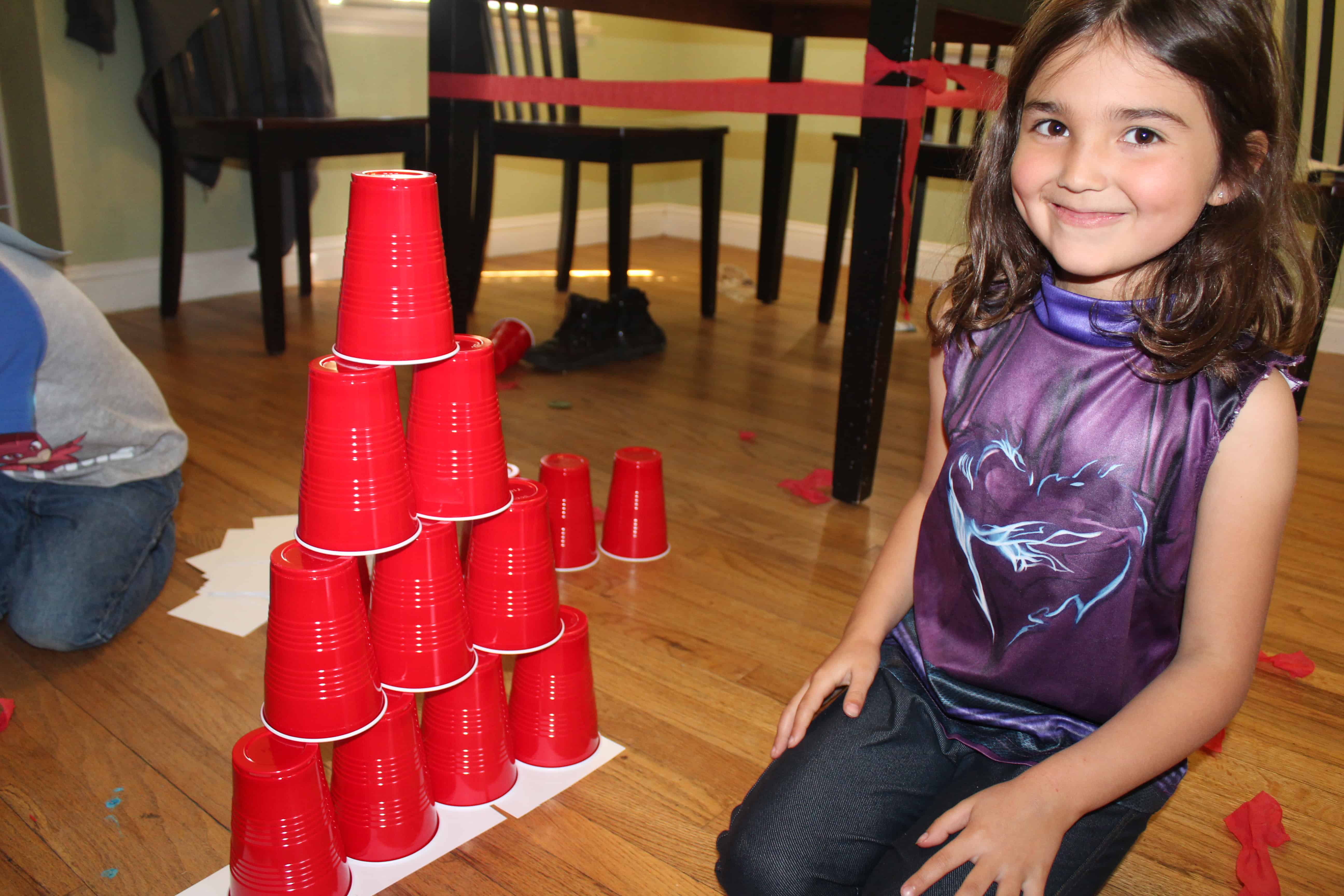 little girl stacking red solo cups into a pyramid