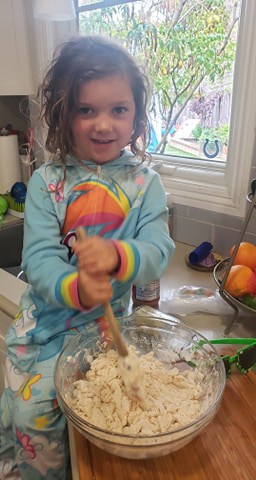 Child Mixing dough made of water, flour, and salt