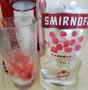 raspberry vodka poured over the top of a homemade snow cone