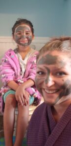 a mom and a daughter with mud masks on their faces