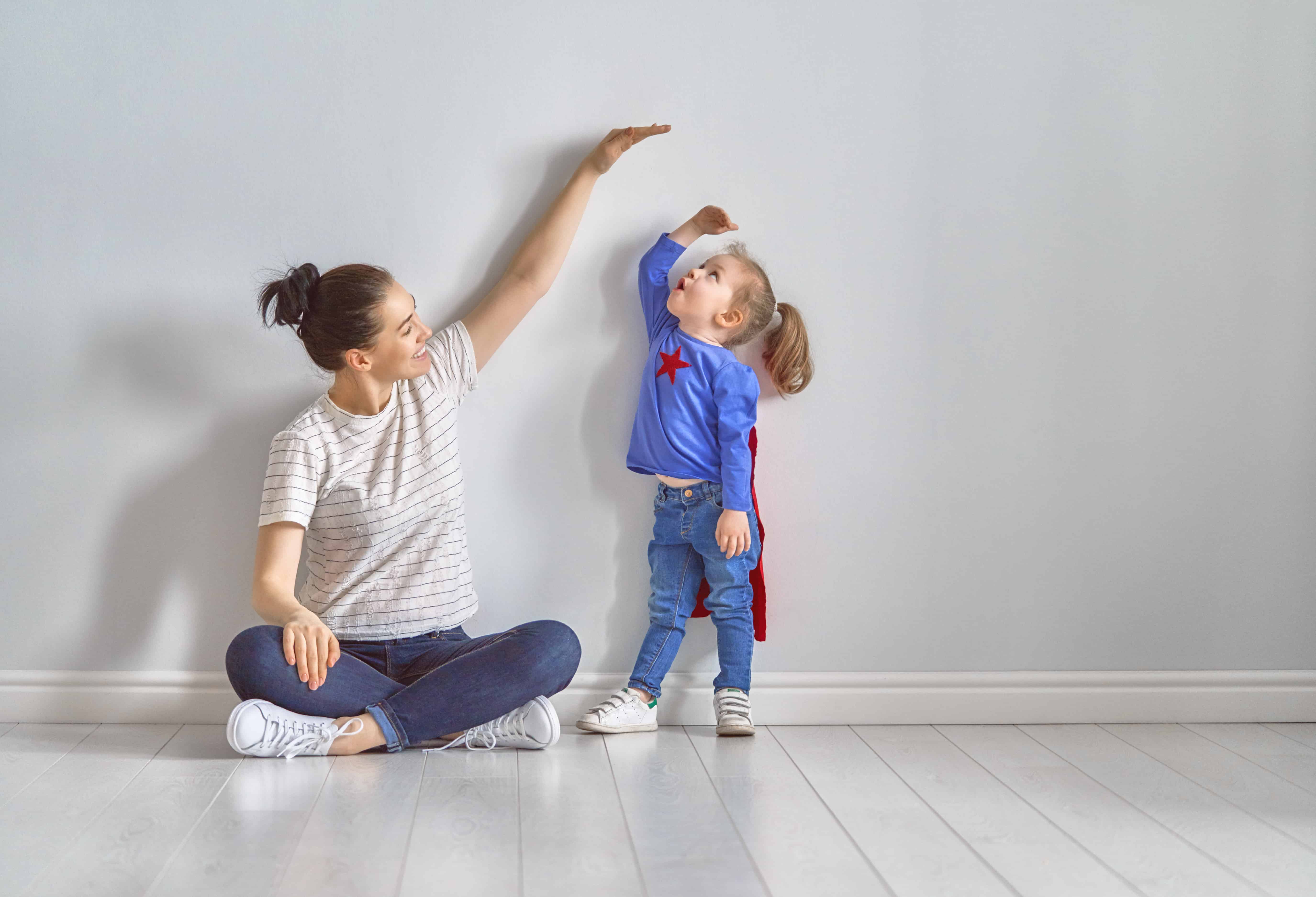 a mom measuring how tall her preschooler is getting