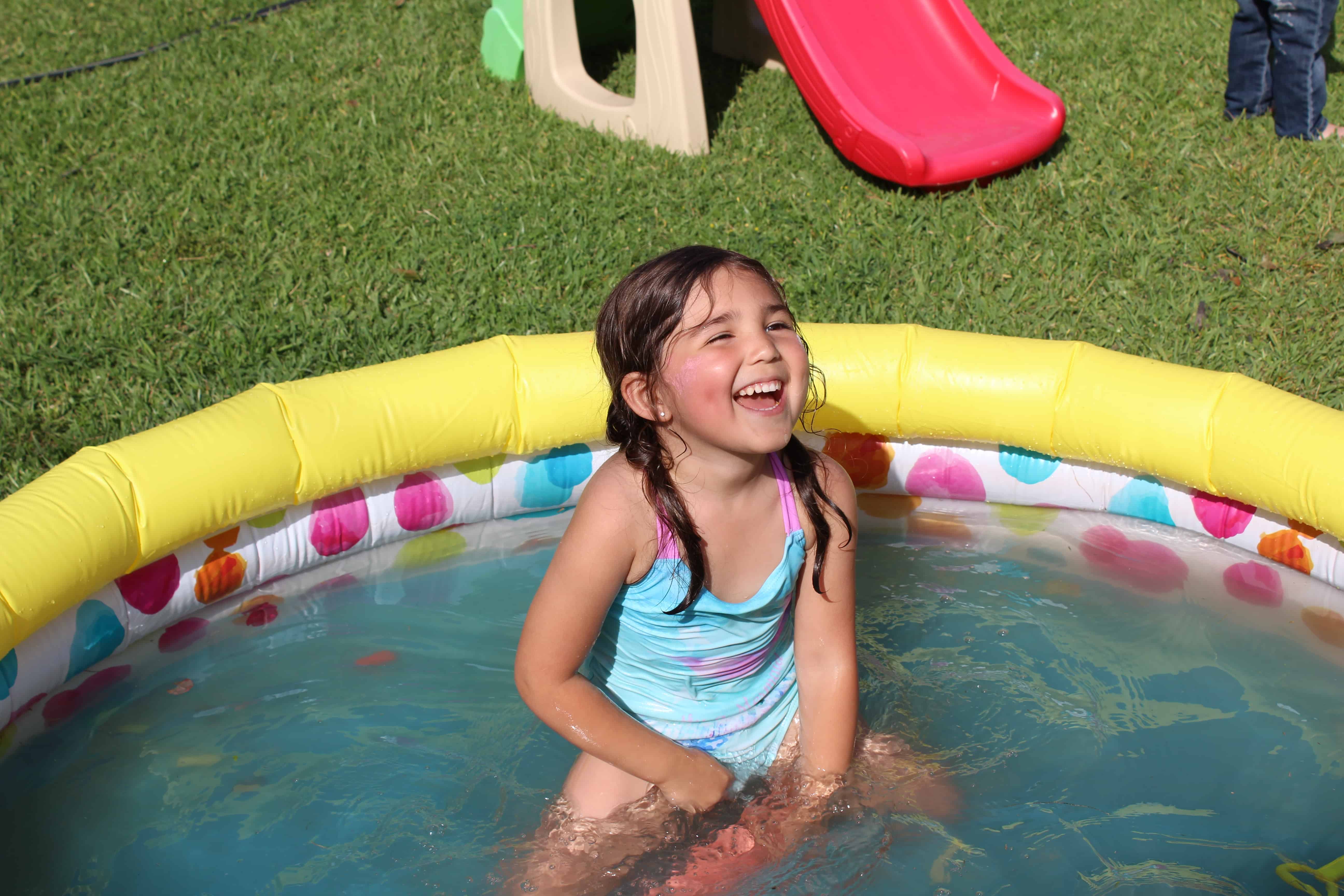 Little girl smiling in inflatable pool