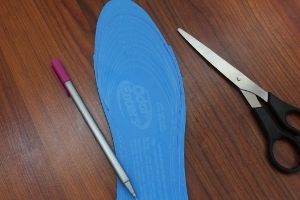 Odor eater customizable insoles trimmed next to scissors and a pen