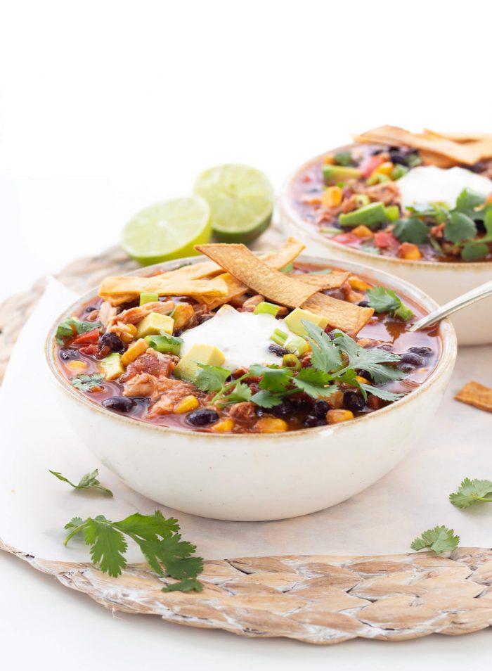 chicken tortilla soup topped with sour cream and tortilla strips