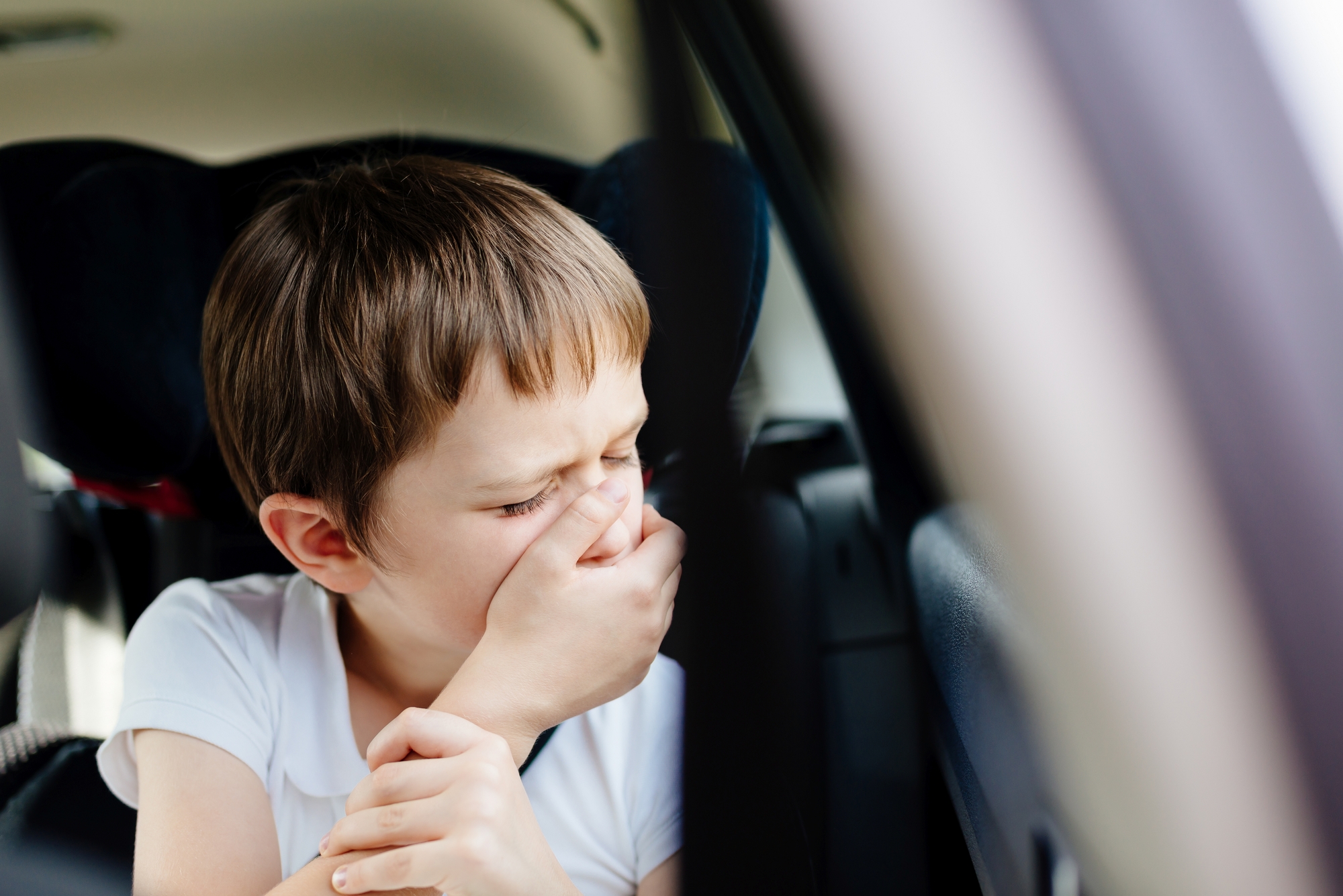 child with motion sickness in the car