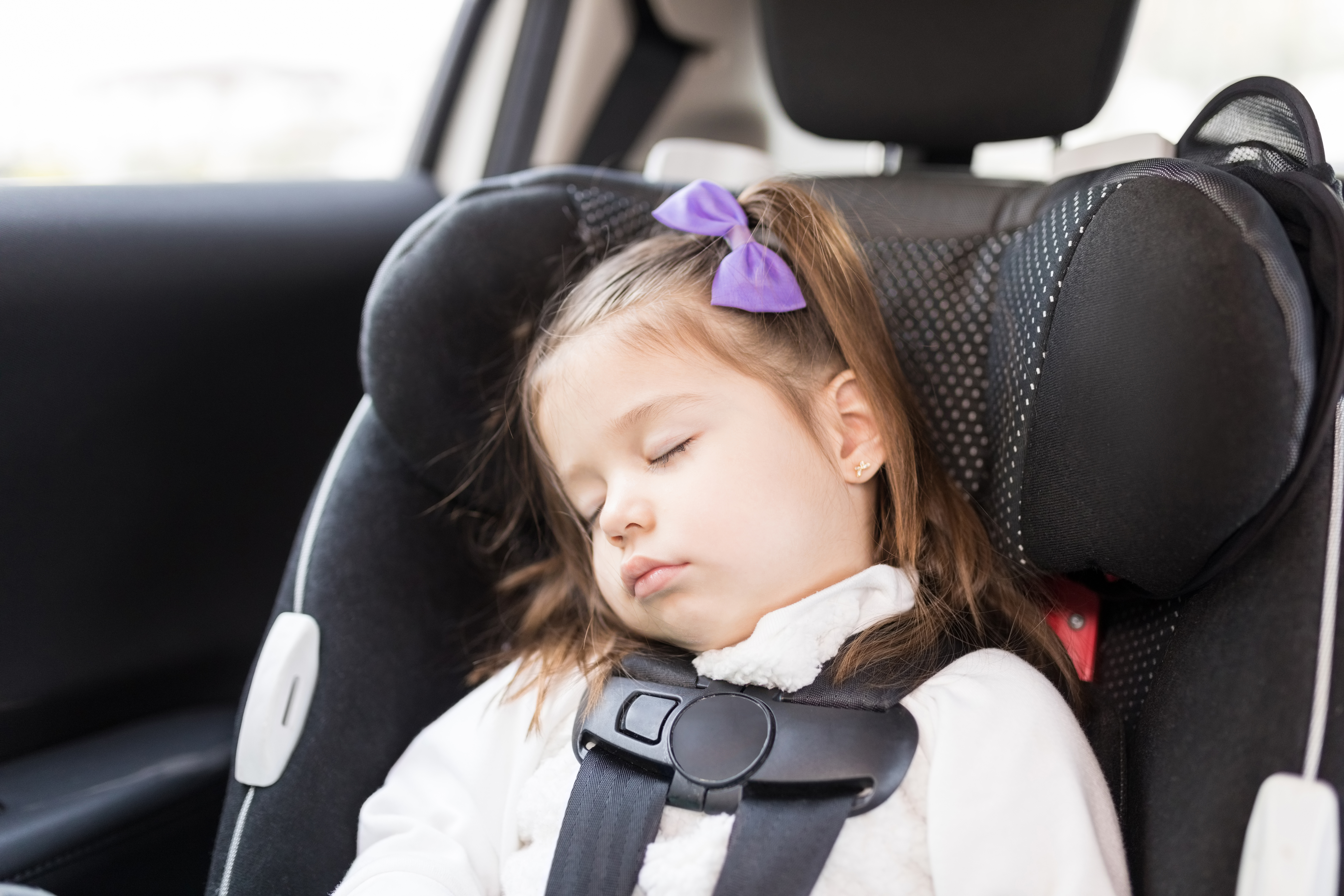 little girl sleeping in car seat