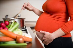 Pregnant woman cooking broccoli