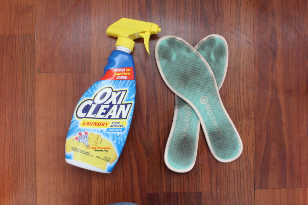 stained insoles next to OcxiClean laundry spray