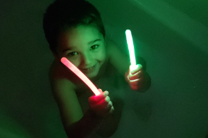 boy taking a glow stick bath