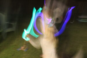 kid dancing with glow sticks; blurry