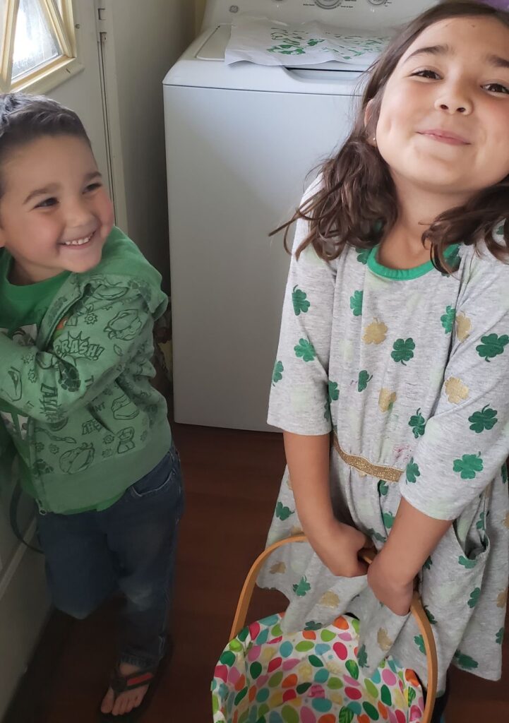 kids holding baskets for rainbow scavenger hunt