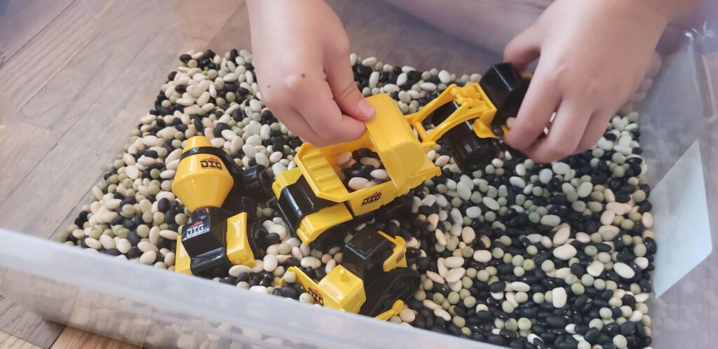 preschooler playing with construction sensory bin