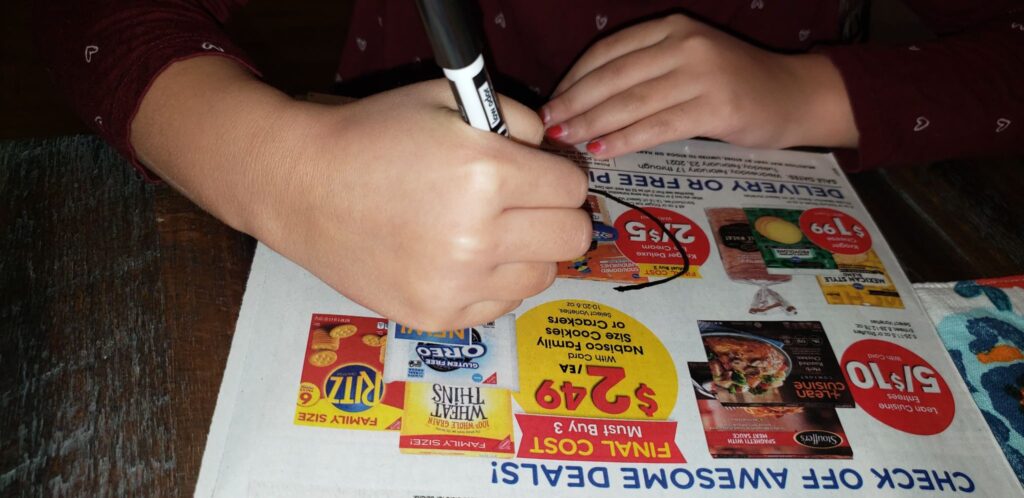 child circling food in grocery ad