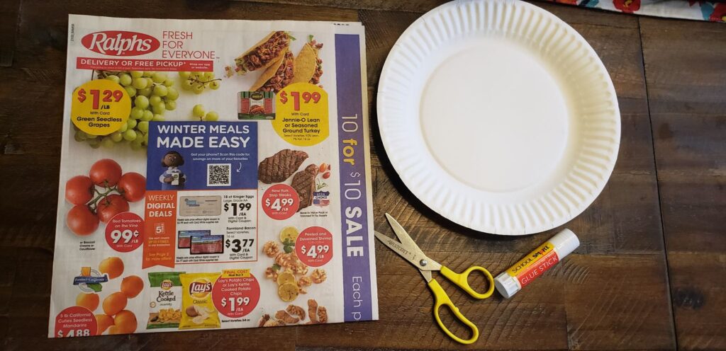 grocery ad; papper plate; scissors; glue