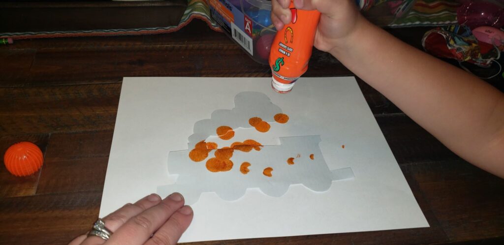 child using dot markers on template