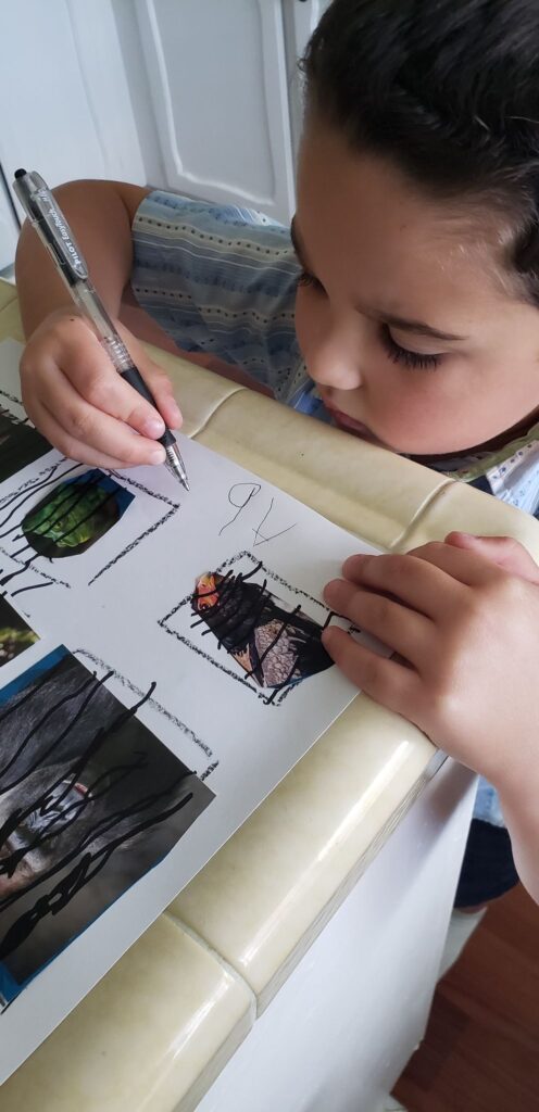 preschooler writing name on Make a Zoo page