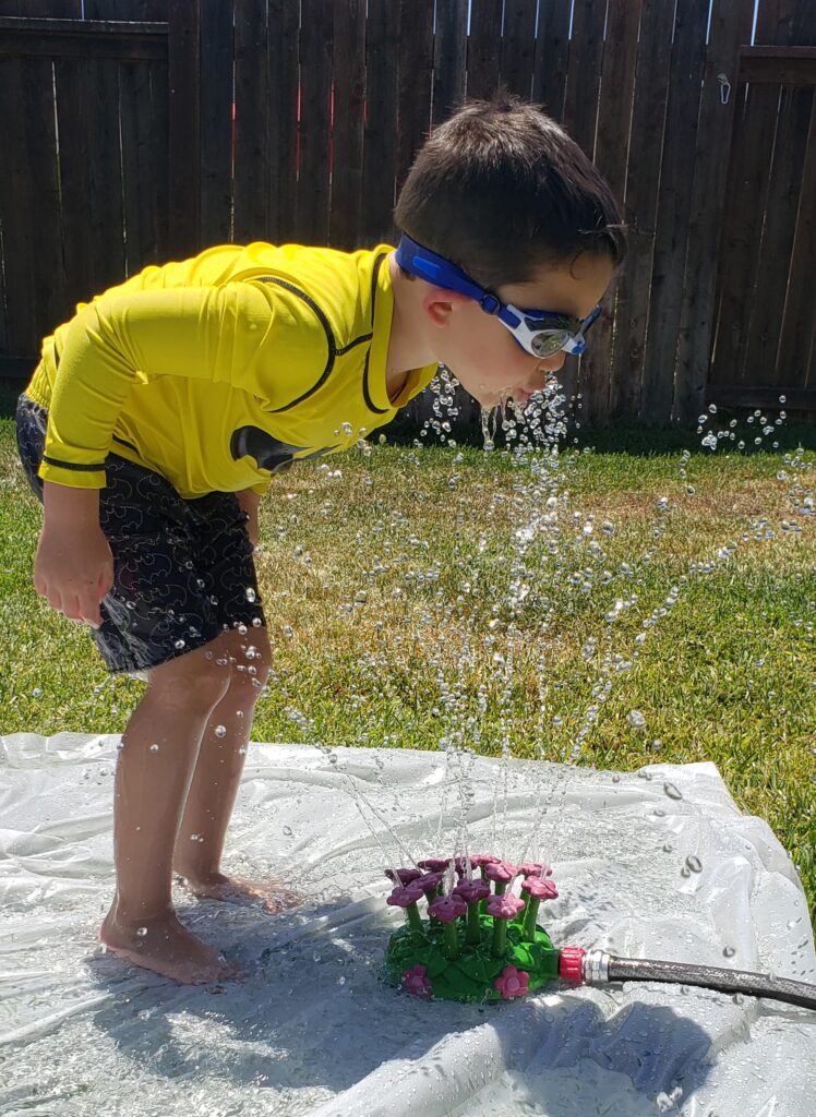 Little boy playing with Melissa and Doug Flower Sprinkler