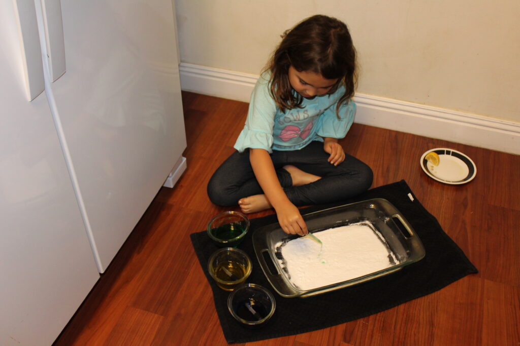 child experimetning with baking soda and vinegar