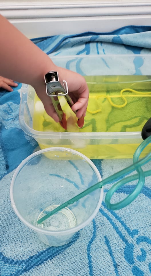 tools for a lemonade sensory bin: tongs, ice, cups