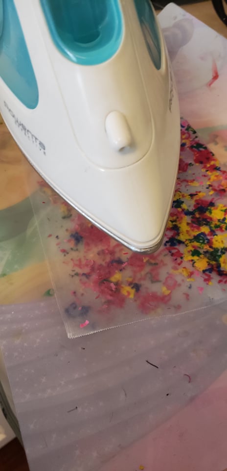 an iron melting crayon shavings in wax paper