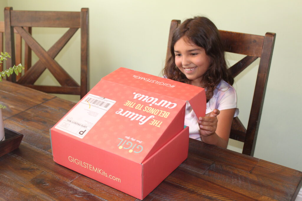 child opening gigil stem kit box