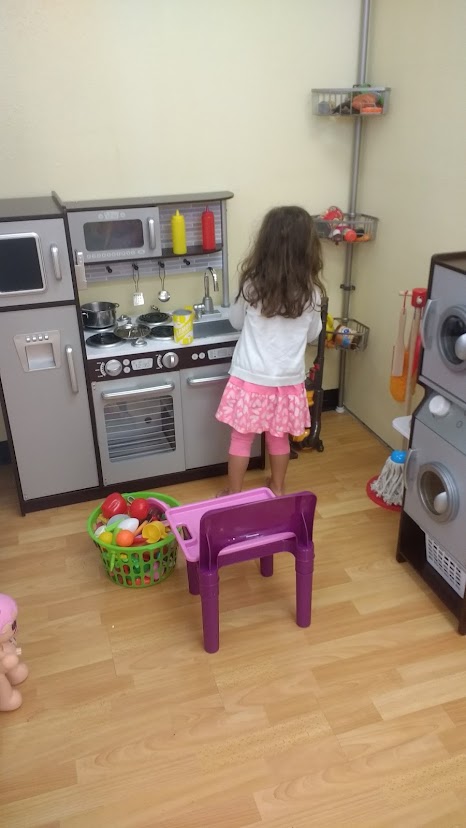 girl playing with toy kitche