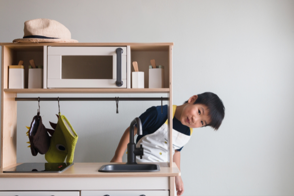 boy playing with play kitchen