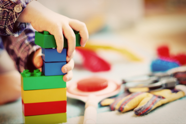 child building with duplo blocks