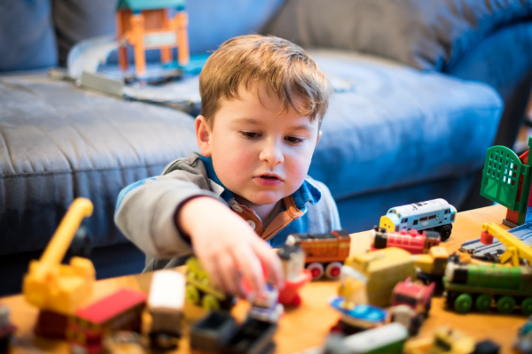 child playing with toy trains