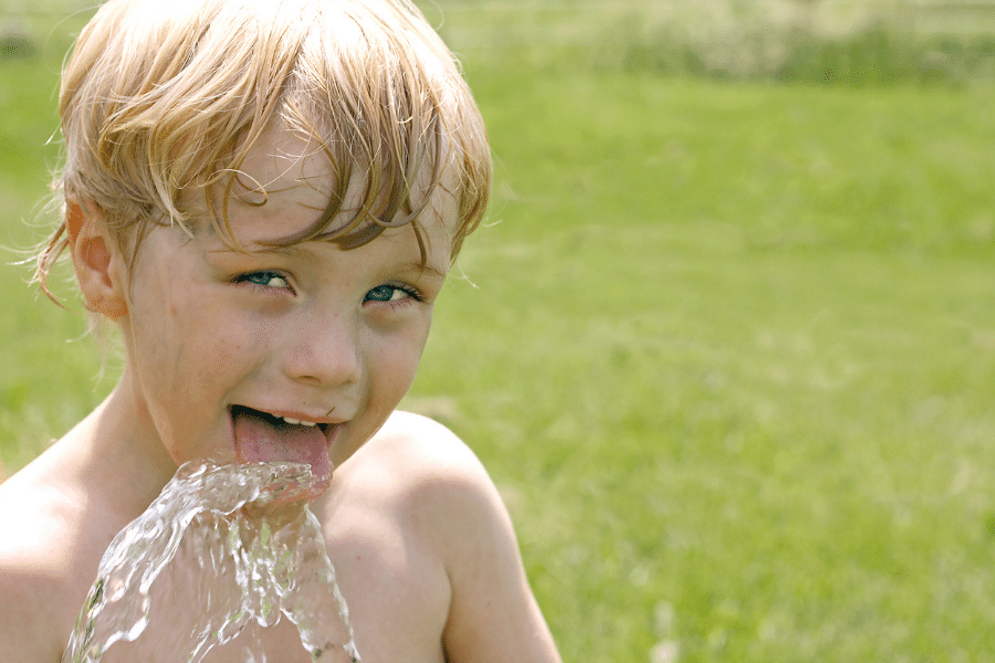 kid drinking from a hose