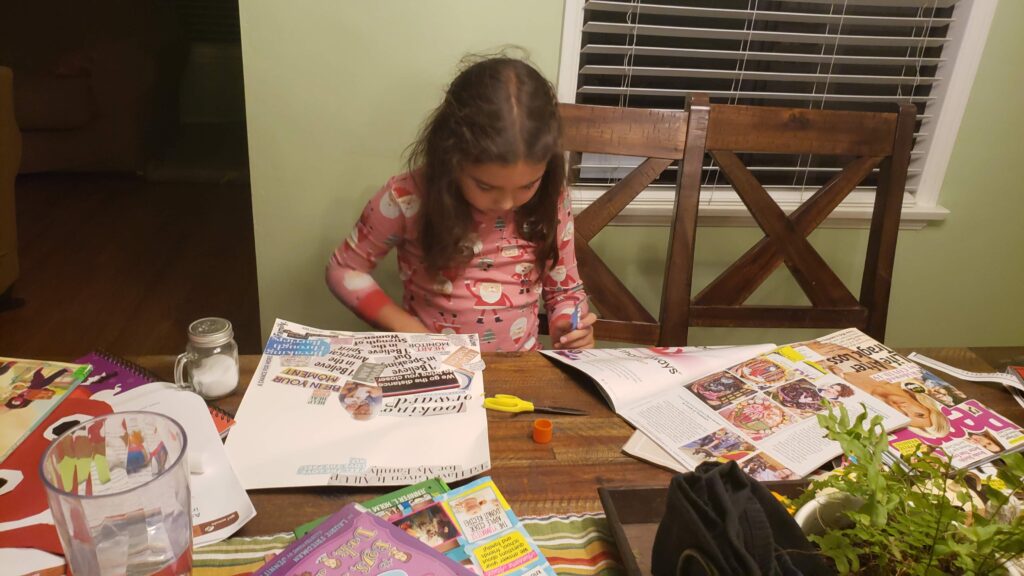 child making collage from magazines
