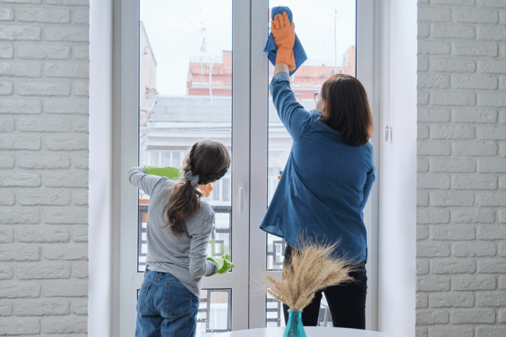 mom and daughter cleaning windows